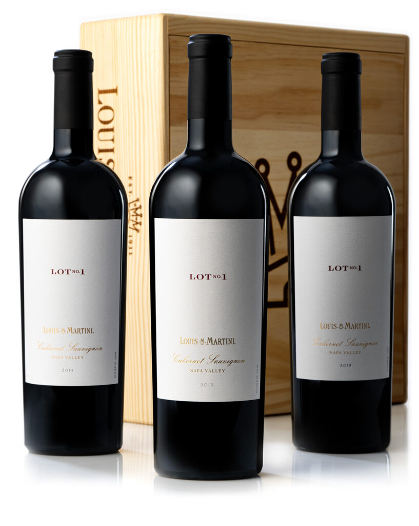 Three bottles of Louis Martini wines beside a wooden gift box.