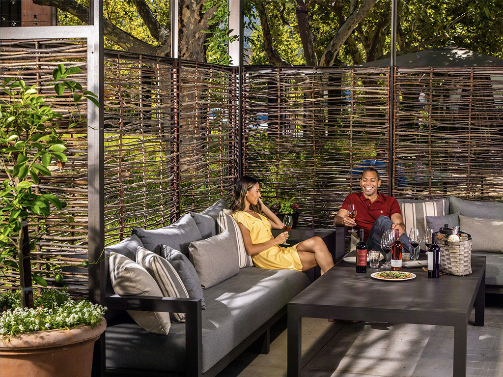 Two people enjoying a Louis Martini wine tasting outside in the cabana.