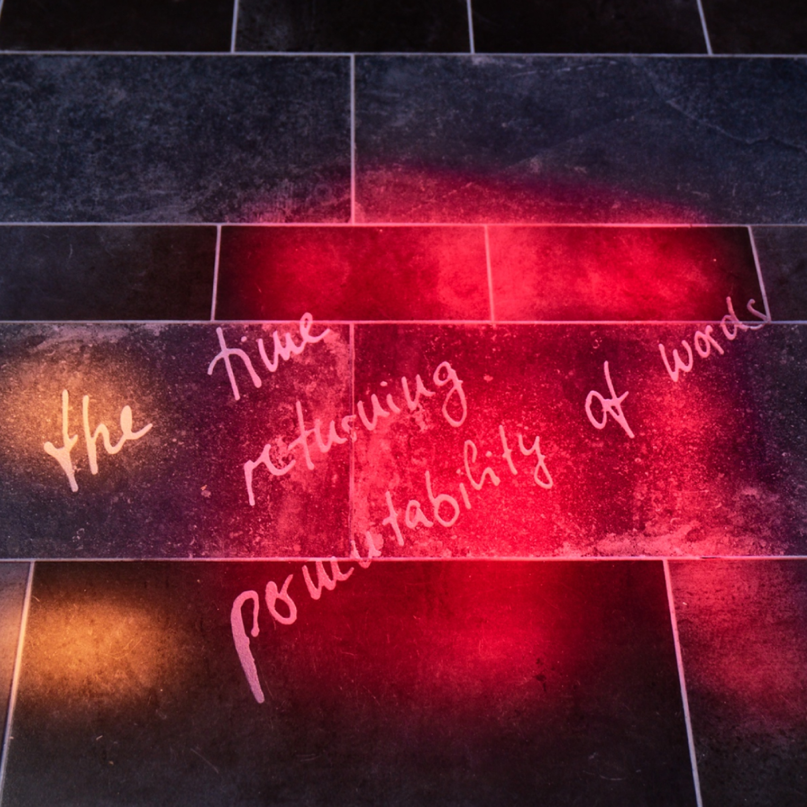 Text fragments sandblasted onto the floor tiles.