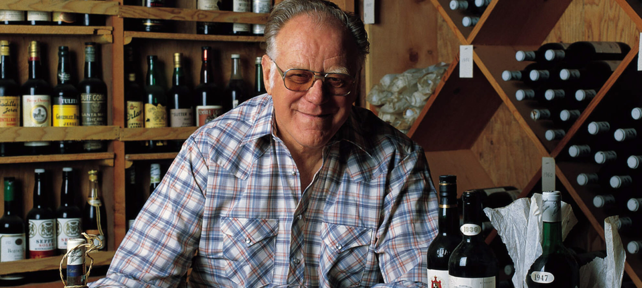 Louis P. Martini surrounded by wines bottles.