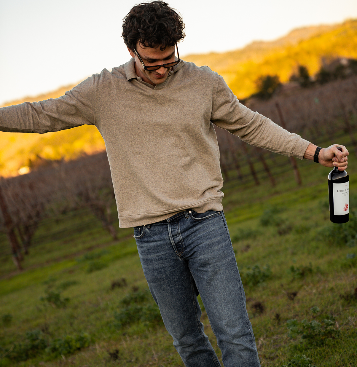 man holding a bottle of 2021 the gryphon in vineyard