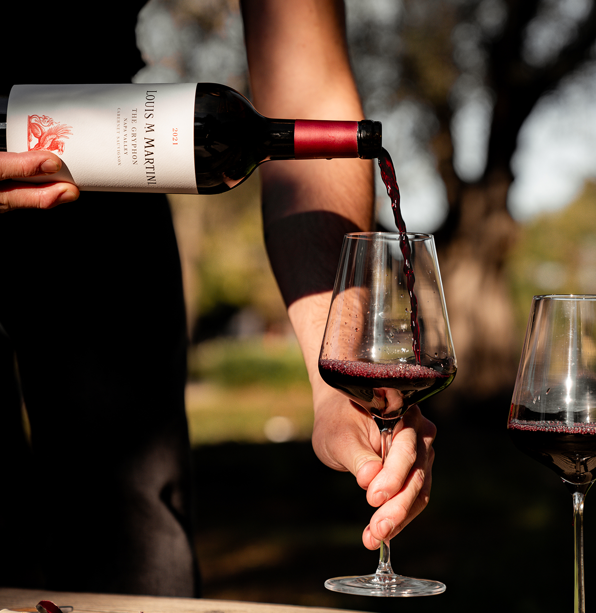 pouring bottle of 2021 the gryphon into wine glass