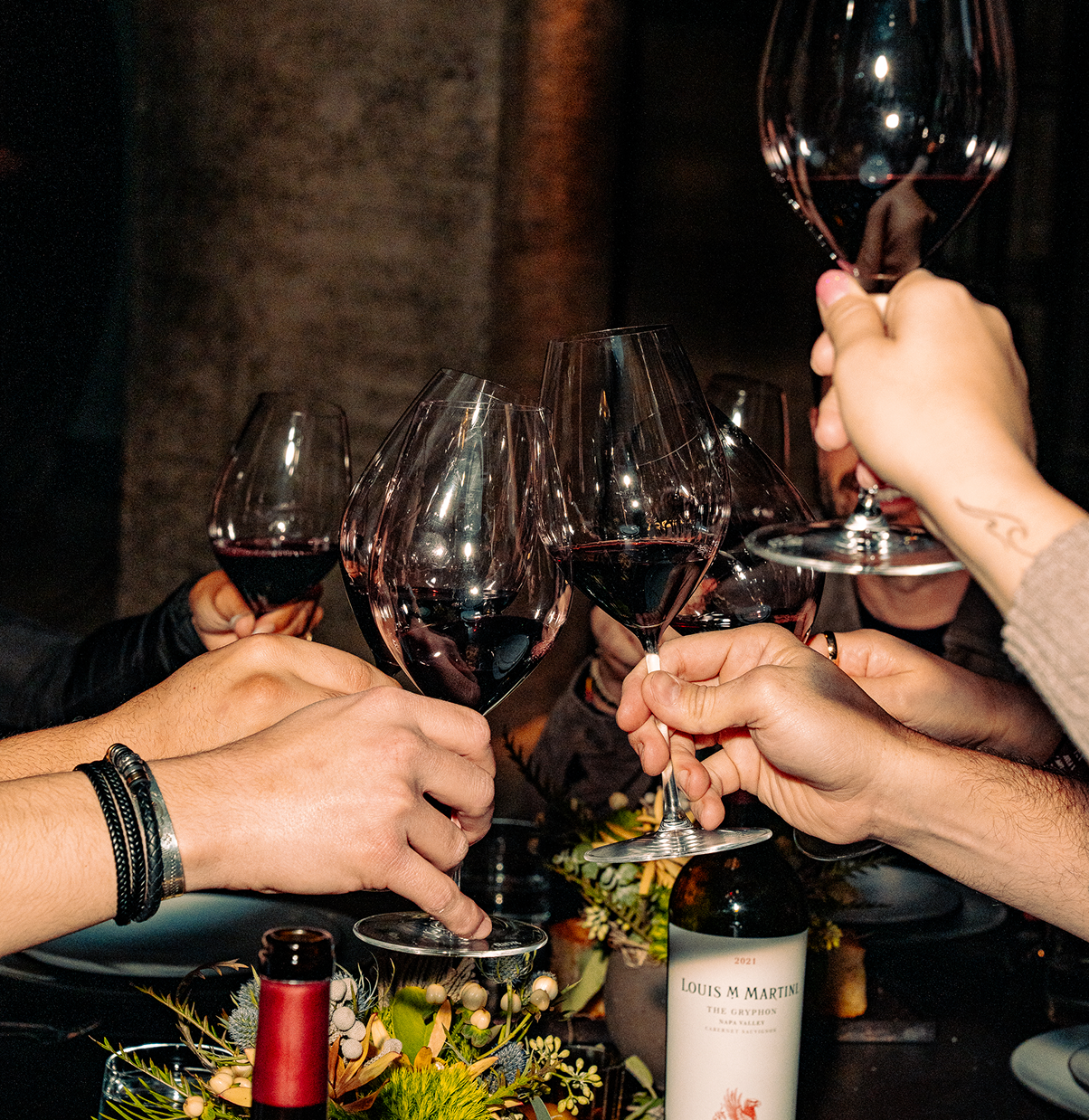 hands holding wine glasses cheersing